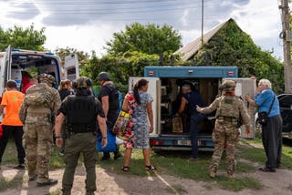 Policemen and medics help people to move from an armoured car to an ambulance from the village of Yarova, that was hit by Russian aerial strike in Donetsk region